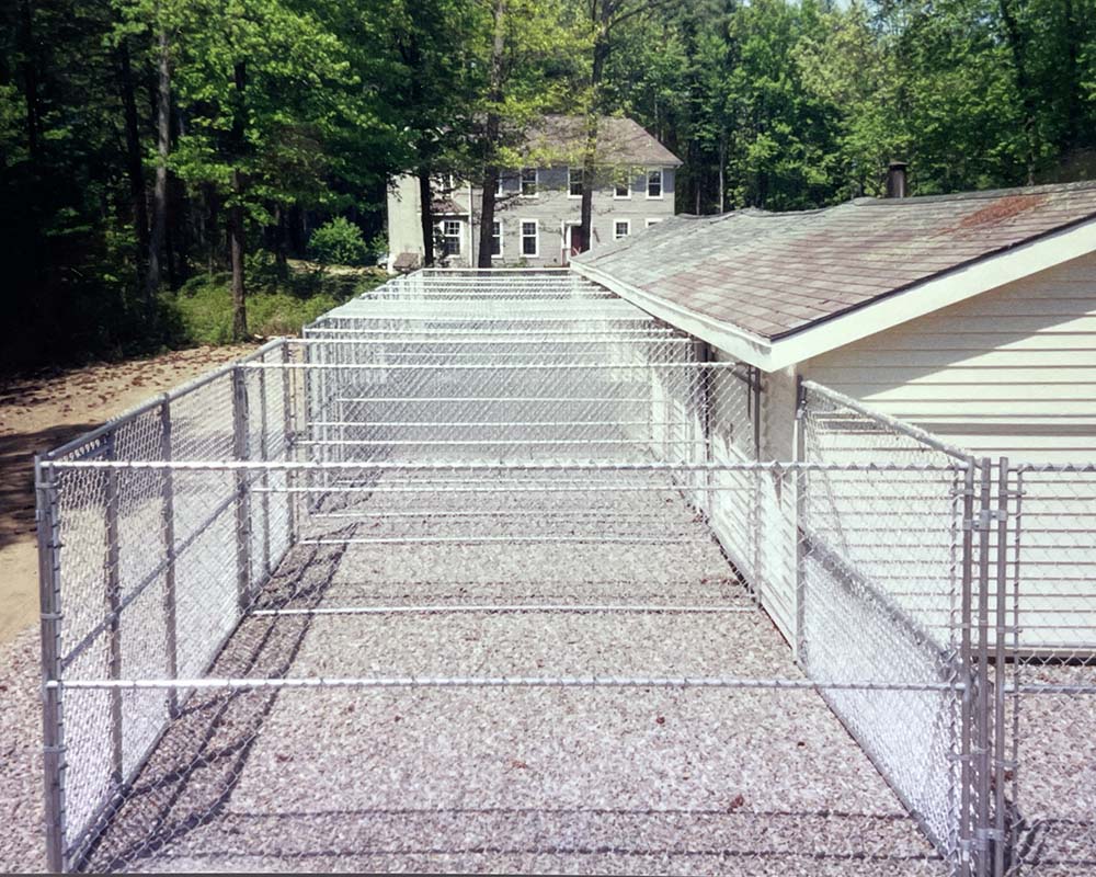 A custom dog enclosure with chain link fencing at a kennel, by Superior Fence Contractors