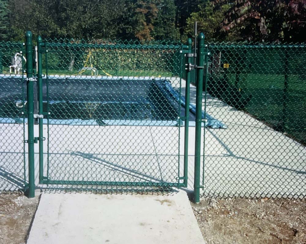 A green chain link fence with gate near Amherst, MA by Superior Fence Contractors