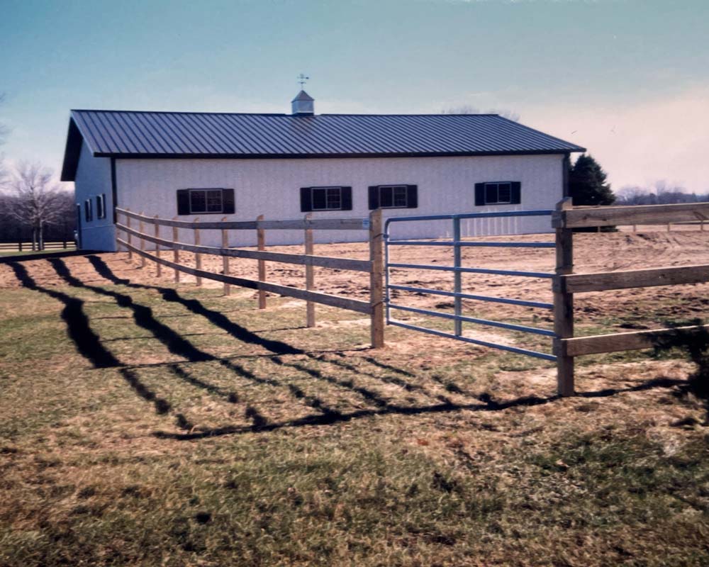 A horse enclosure, with wood fence and metal gate, by Superior Fence Contractors